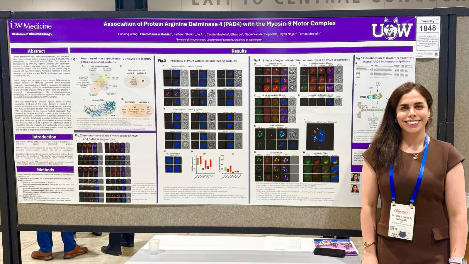 Neela Moadab standing beside a research poster on PAD4 and the myosin-9 motor complex